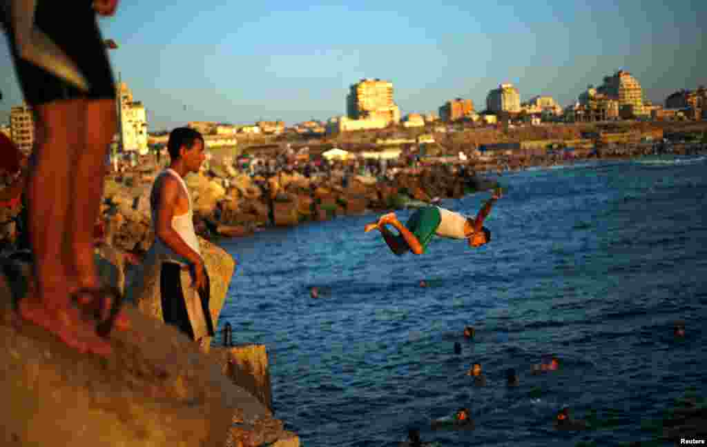 A Palestinian youth dives into the sea to cool off during a hot day at the seaport of Gaza City.