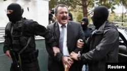 Extreme-right Golden Dawn party senior lawmaker Christos Pappas is escorted by anti-terrorism police officers to a courthouse, Athens, Oct. 3, 2013.
