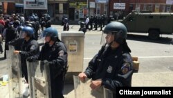Polisi kota Baltimore mengamankan gedung-gedung dari aksi demonstrasi rusuh di sana (28/4).