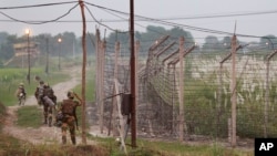 FILE - Indian Border Security Force soldiers walk near the India-Pakistan international border area at Gakhrial boder post in Akhnoor sector, about 48 kilometers (30 miles) from Jammu, India, Oct. 1, 2016.