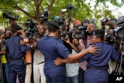Congolese police officers hold back members of the media as Congo opposition candidate Martin Fayulu leaves the constitution court in Kinshasa, Congo, Saturday Jan. 12, 2019.