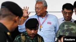 People's Democratic Reform Committee (PDRC) leader Suthep Thaugsuban (C) waves to media as he leaves the criminal court in Bangkok, May 26, 2014.