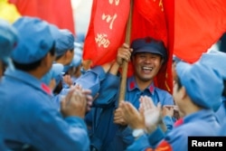 Participants dressed in replica Red Army uniforms welcome teammates as they return from a hike through the mountains during a Communist team-building course extolling the spirit of the Long March outside Jinggangshan, Jiangxi province, China, Sept. 14, 2017.