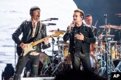 FILE - The Edge (left) and Bono of U2 perform at the Bonnaroo Music and Arts Festival, June 9, 2017, in Manchester, Tennessee.