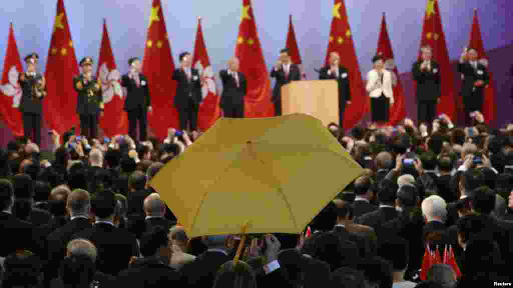 香港特区行政长官梁振英（右五）和其他官员国庆祝酒时，区议员司马文打出黄色雨伞