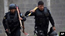 Policías portan herramientas para ser usadas en una operación para rescatar a cuatro guardias de una prisión que fueron tomados en rehenes en un disturbio en el reformatorio Centro Correctional Etapa II, en San José Pinula, Guatemala, el lunes, 20 de marzo, de 2017.