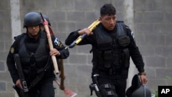 Police carry tools, including axes and a large plier, to use in an operation that aims to rescue four jail guards who were taken in the midst of a prison riot at the Centro Correccional Etapa II reformatory in San Jose Pinula, Guatemala, March 20, 2017. 