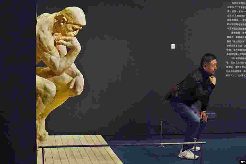 Một người chụp hình trước bức tượng "Người Suy Tư" của Auguste Rodin của tại Viện Bảo tàng Quốc gia ở Bắc Kinh của Trung Quốc.
