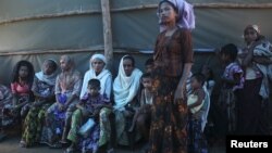 Shofica Belcom, 25, waits with other mothers at a Burma Red Cross health clinic near Sittwe, capital of Burma's Rakhine state, October 14, 2012. 