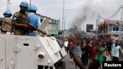 Warga meneriakkan slogan-sloga anti Presiden Kongo, Joseph Kabila, di tengah patroli pasukan perdamaian PBB (MONUSCO) (20/12). Kinshasa, Kongo (foto: REUTERS/Thomas Mukoya)
