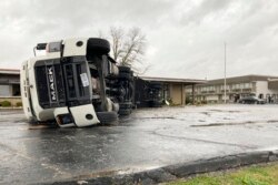 Un gran semirremolque es volcado y empujado contra un edificio en Bowling Green, Kentucky, el sábado 11 de diciembre de 2021.