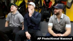 FILE - Boston Bruins players, from left, Frank Vatrano, Noel Acciari and Tyler Randell sit in the locker room during an end of season media availability at TD Garden in Boston.