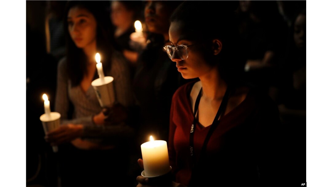 Natalynn Rivis, a student at University of Nevada Las Vegas, right, takes part in a vigil Monday, Oct. 2, 2017, in Las Vegas. A gunman on the 32nd floor of the Mandalay Bay casino hotel rained automatic weapons fire down on the crowd of over 22,000.