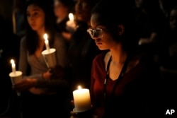 Natalynn Rivis, a student at University of Nevada Las Vegas, right, takes part in a vigil Monday, Oct. 2, 2017, in Las Vegas. A gunman on the 32nd floor of the Mandalay Bay casino hotel rained automatic weapons fire down on the crowd of over 22,000.