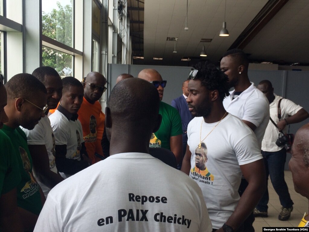 Des Ivoiriens avec un tee-shirt &quot;repose en paix Cheiky&quot;, à l&#39;aéroport d&#39;Abidjan, le 15 juin 2017. (VOA/Georges Ibrahim Tounkara)