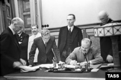 Soviet Union -- USSR. Moscow. Minister of foreign affaires of the USSR Vyacheslav Molotov signs a secret supplement to the Non-aggression Pact between Germany and the USSR (the Molotov-Ribbentrop Pact). Josef Stalin is pictured at the signing ceremony, Moscow, September 28, 1939