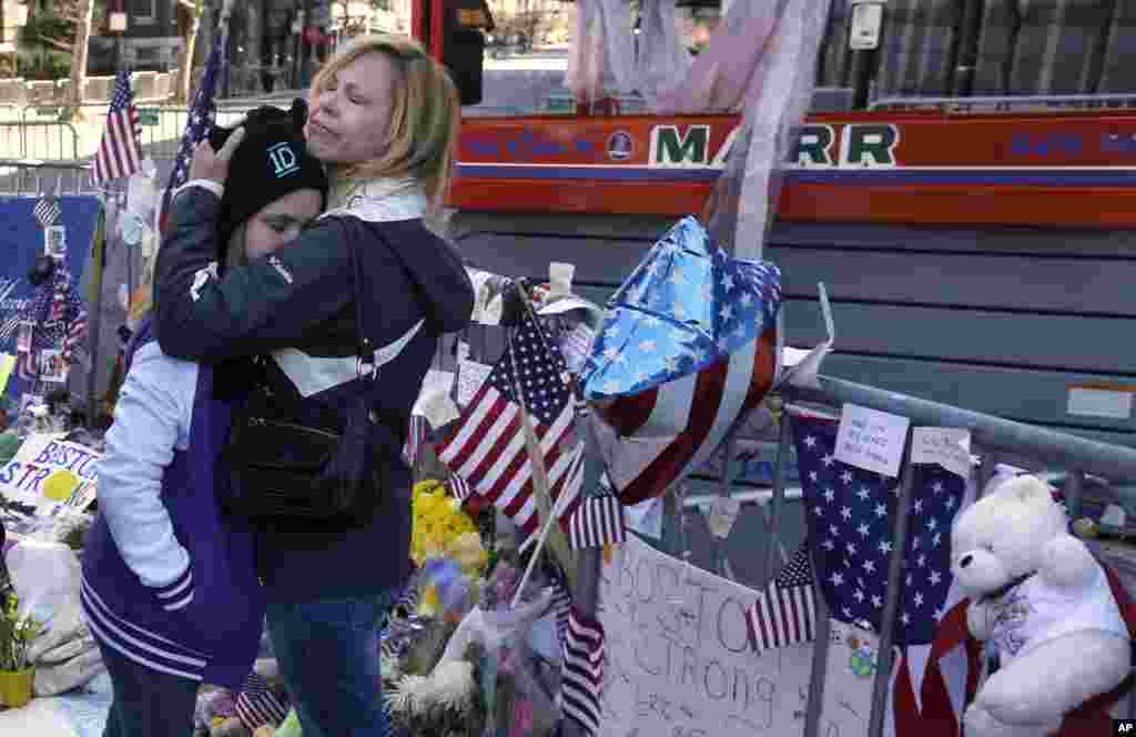 Holly Holland, right, of St. Louis, hugs her daughter Katie Holland while visiting a makeshift memorial in Boston. The memorial sits on Boylston Street, not far from where two bombs exploded near the finish line of the Boston Marathon.