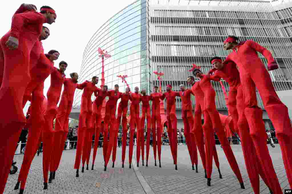 French performance group Compagnie Off members gather before performing &#39;Les Girafes&#39;, a stilt-walking show, at Roppongi Hills in Tokyo. 