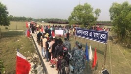 Rohingya refugees stand in line after they disembarked from a Bangladesh Navy ship to the island of Bashar Char in Noakhali on December 4, 2020.