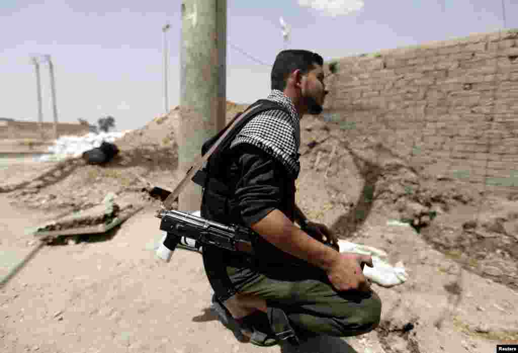 A Free Syrian Army fighter holds his weapon in Raqqa province, east Syria, May 6, 2013.
