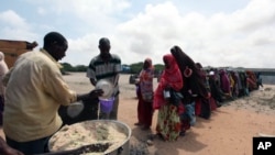 Internally displaced Somali people stand in line as they wait for cooked food in Hodan district, south of capital, Mogadishu, September 5, 2011.