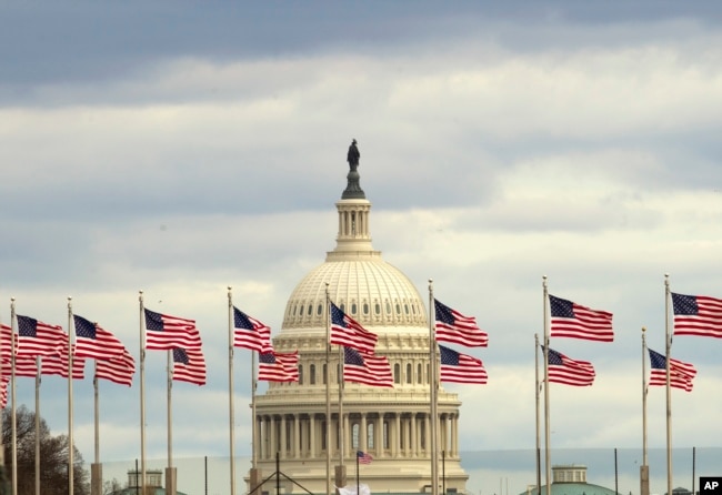 Flags fly in front of the U.S. Capitol in Washington, Tuesday morning, Jan. 1, 2019, as a partial government shutdown stretches into its third week.
