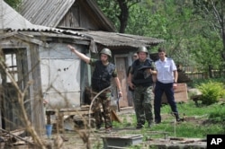 Members of a Russian investigative committee examine a house after shelling in Donetsk, Russia, July 13, 2014.