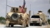 FILE - The U.S. flag flutters on a military vehicle in Manbij, Syria, May 12, 2018.