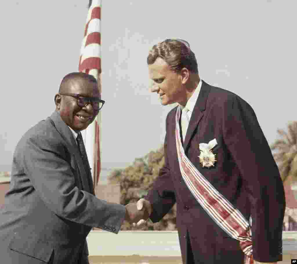 L'évangéliste Billy Graham reçoit le Grand Commandeur de l'Ordre Humain de la Rédemption Africaine du président du Liberia, William V.S. Tubman en 1960.