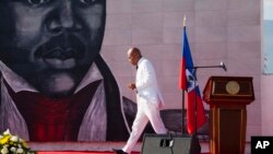 FILE - Haiti's then-President Michel Martelly returns to his seat after delivering a speech in Port-au-Prince, Oct. 17, 2015. Former Haiti officials in Martelly's administration have been forbidden to leave the country in light of a report of electoral fraud.