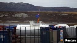 Les drapeaux des Îles Falkland devant un dépôt des machines et de matériel utilisé dans l'exploration pétrolière est vu à Port Stanley, 13 mars 2012. 