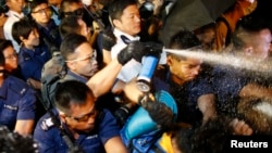 Police use pepper spray as they clash with pro-democracy protesters at an area near the government headquarters building in Hong Kong early October 16, 2014.