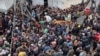 (FILE) Palestinians gather to receive bread from a bakery, amid the Israel-Hamas conflict, amid the ongoing conflict between Israel and Hamas, in Deir Al-Balah in the central Gaza Strip, November 29, 2024.