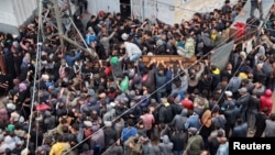 (FILE) Palestinians gather to receive bread from a bakery, amid the Israel-Hamas conflict, amid the ongoing conflict between Israel and Hamas, in Deir Al-Balah in the central Gaza Strip, November 29, 2024.