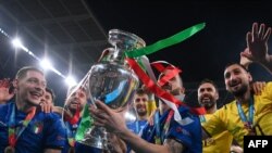 Timnas Italia berfoto dengan Piala Eropa setelah memenangi laga final kontra Inggris di Stadion Wembley, London, Minggu, 11 Juli 2021. (Foto: Laurence Griffiths/Pool/AFP)