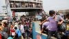 Pekerja migran dan pekerja turun dari feri yang penuh sesak di terminal feri Mawa di Munshiganj, Bangladesh. Kebakaran besar melanda satu feri sungai yang penuh sesak di Bangladesh selatan Jumat (24/12) pagi, menyebabkan sedikitnya 39 orang tewas dan 72 terluka. (Foto: Reuters)