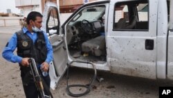 An Iraqi policeman inspects the site of a suicide attack at a polling center in Kirkuk, 290 kilometers (180 miles) north of Baghdad, April 28, 2014.