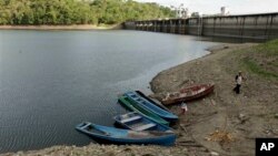 Seorang petani dan putranya meninggalkan perahu mereka yang ditambatkan di tepi Danau Bayano, Panama, setelah melintasi danau tersebut, Selasa (7/5). Bendungan tersebut memasok listrik ke seluruh negeri, tetapi Panama diperkirakan harus mulai penjatahan listrik jika krisis energi terus berlanjut karena terlambatnya awal musim hujan. Pemerintah Panama akan menutup semua sekolah selama tiga hari mulai Rabu (8/5) untuk menghindari pemadaman.