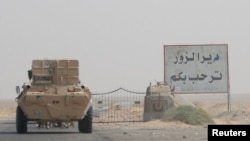 FILE - A road sign welcomes people to the town of Deir el-Zour in Syria, Sept. 20, 2017.