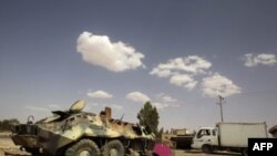 Xe thiết giáp của binh sĩ của ông Gadhafi bị hư vì oanh kích được bỏ nằm bên ngoài làng al-Qawalish