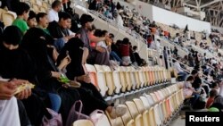 Saudi women watch the soccer match between Al-Ahli against Al-Batin at the King Abdullah Sports City in Jeddah, Saudi Arabia, Jan. 12, 2018.