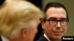 US Treasury Secretary Steve Mnuchin (R) listens to US President Donald Trump speak during a 'strategic initiatives"'lunch at the White House in Washington, Feb. 22, 2017