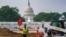 Workers repair a park near the Capitol in Washington, July 21, 2021, as senators struggle to reach a compromise over how to pay for nearly $1 trillion in public works spending, a key part of President Joe Biden's agenda.