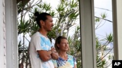 Matt Saunter, left, and Naomi Worcester stand on the porch of their home while under quarantine in Honolulu, Nov. 6, 2020. 
