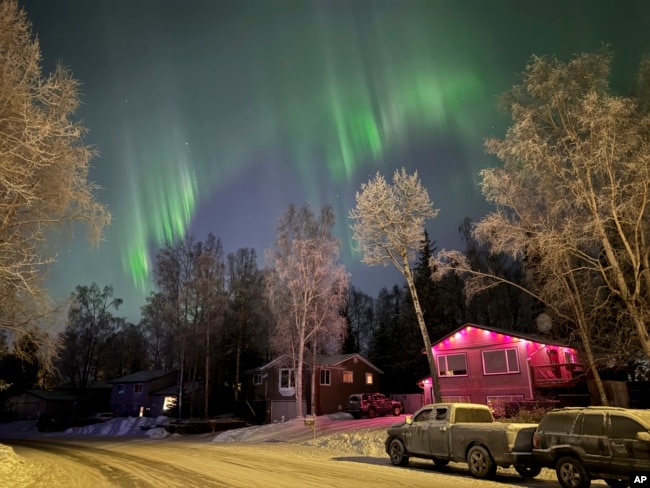 FILE - The northern lights appear over homes in Anchorage, Alaska, on Wednesday, Jan. 1, 2025. (AP Photo/Mark Thiessen)