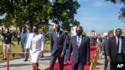 FILE - Haiti's President Jovenel Moise, center, accompanied by his wife Martine, and Prime Minister Joseph Jouthe, center right, in Port-au-Prince, Haiti. 