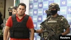 Marinir Meksiko mengawal Jesus Alfredo Guzman, alias El Gordo, saat diperlihatkan kepada media di Mexico City, 2012. 