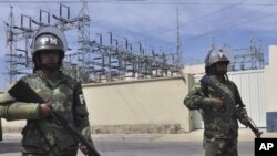 Military police stand guard outside Transportadora de Electricidad, the Spanish electricity grid's Bolivian subsidiary, in Cochabamba, Bolivia, Tuesday, May 1, 2012. 