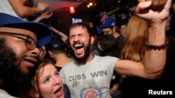 Fans of National League baseball team Chicago Cubs who gathered to watch the game at Kelly's bar celebrate their Major League Baseball World Series game 7 victory against American League's Cleveland Indians in Manhattan, New York, Nov. 3, 2016. 