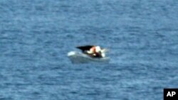 Un pasajero del crucero tomó esta fotografía de tres náufragos a bordo de una embarcación a la deriva ignorada por el buque.